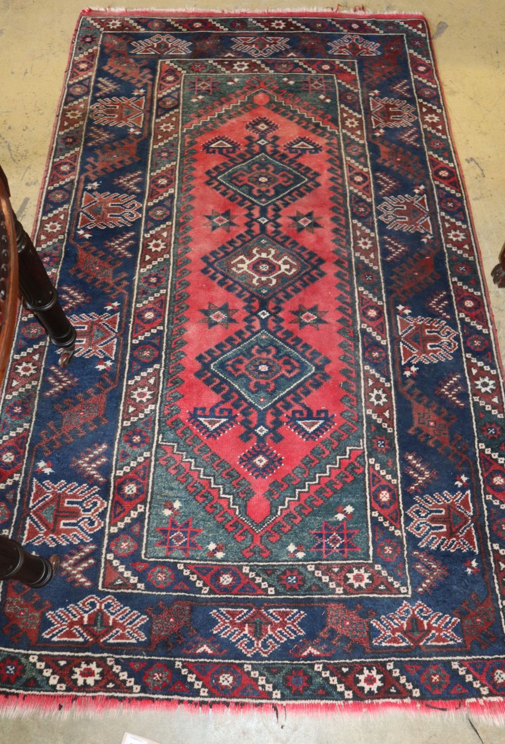 A Caucasian red ground rug, 200 x 115cm